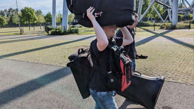 Alle müssen zum Ausbau mit anpacken und die Instrumente mitsamt Schlagzeug in den Park tragen.